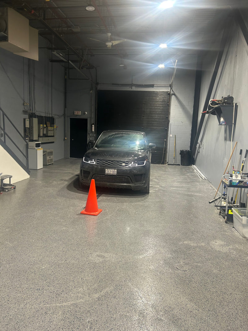 Completed flake epoxy floor with vehicle inside detailing bay
